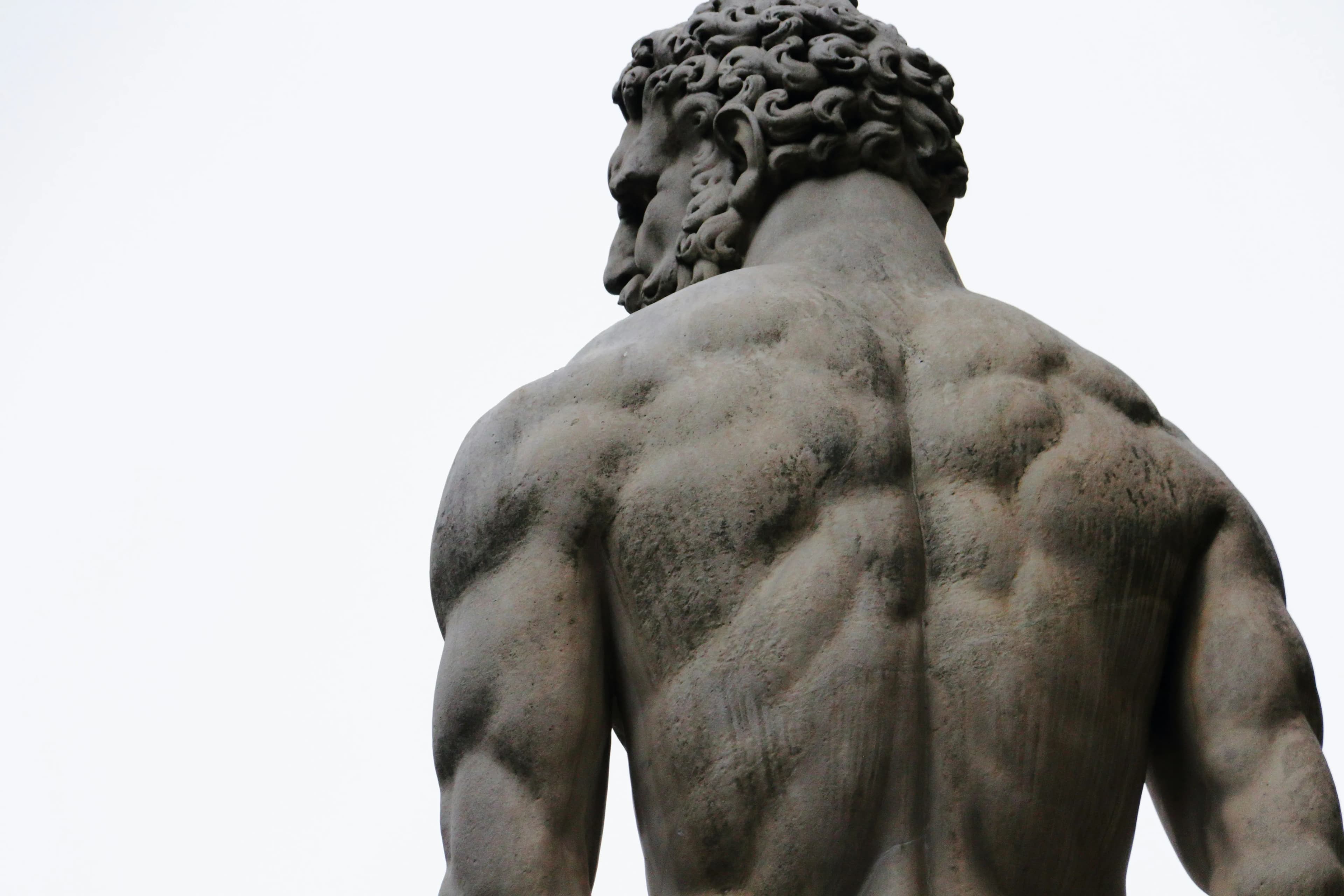 Greek-style statue of muscular, defined, man, with heavy beard